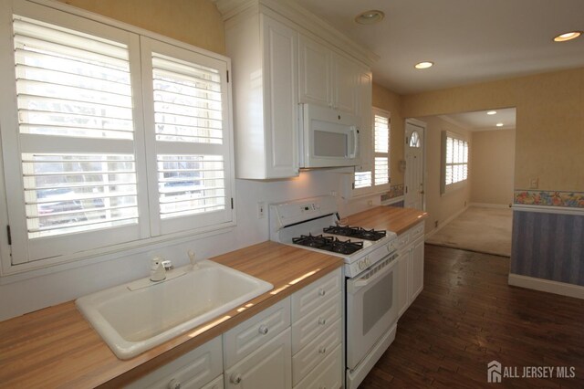 kitchen featuring butcher block counters, sink, white appliances, and white cabinetry