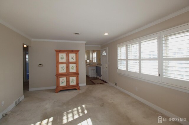 unfurnished living room with light colored carpet and crown molding