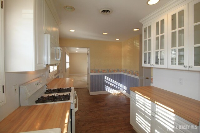 kitchen with white cabinetry, white appliances, and dark hardwood / wood-style flooring