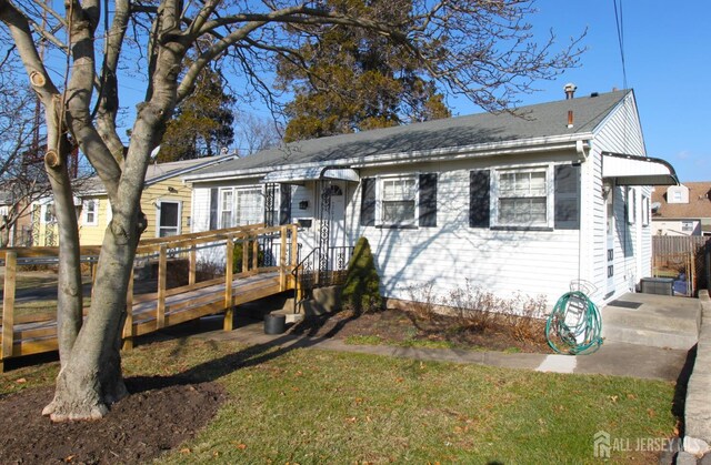 view of front facade featuring a wooden deck and a front yard