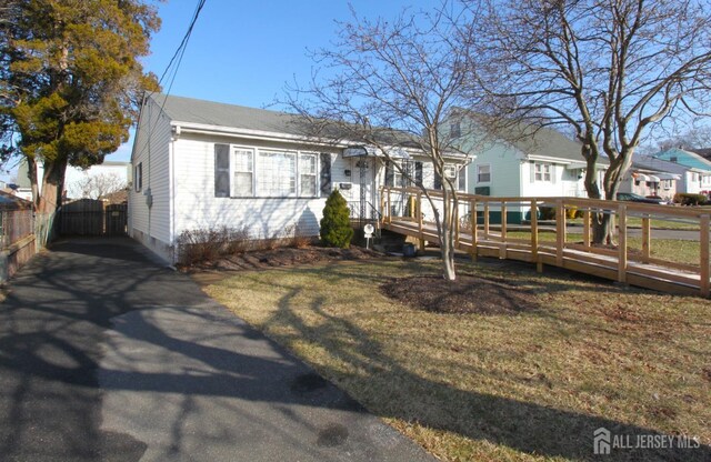 view of front of home featuring a wooden deck and a front lawn