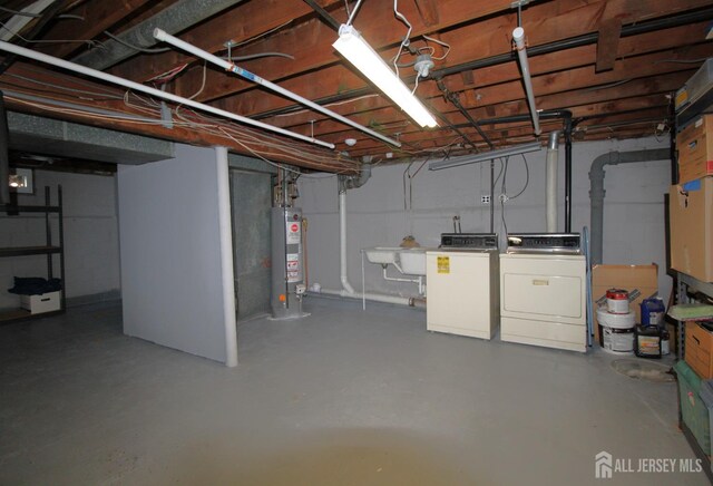 basement with sink, washing machine and clothes dryer, and gas water heater