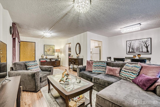 10 N Wood Ave N Unit 215, Linden, NJ 07036 - living room with light wood-style flooring, a textured ceiling, and a chandelier