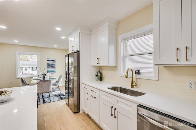 24 Savoy St, Colonia, NJ 07067 - kitchen featuring a sink, appliances with stainless steel finishes, white cabinetry, light wood-type flooring, and light stone counters
