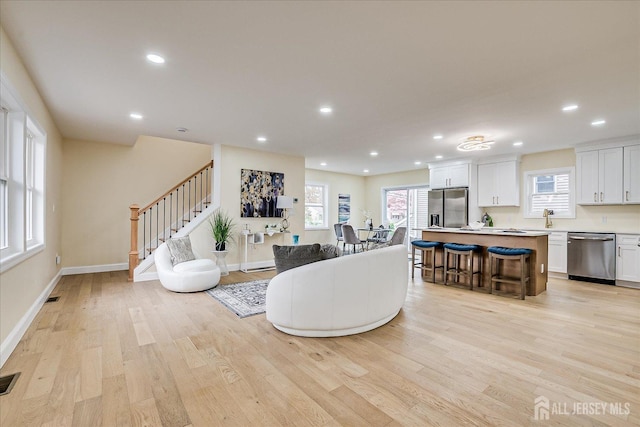 24 Savoy St, Colonia, NJ 07067 - living area featuring light wood-style flooring, plenty of natural light, stairway, recessed lighting, and baseboards