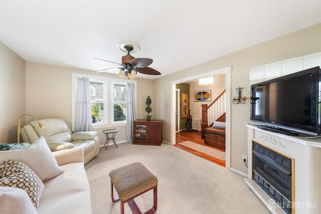 carpeted living room with ceiling fan