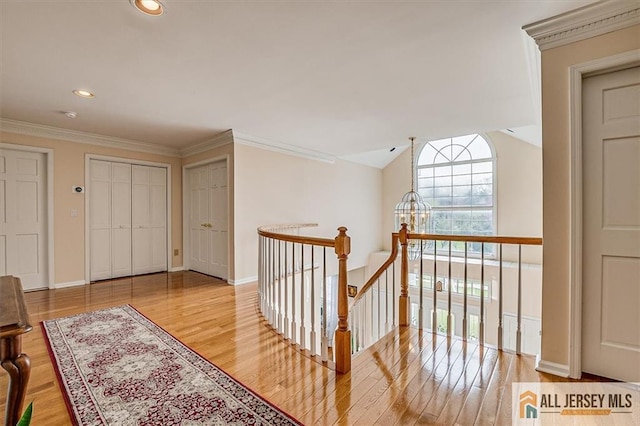 27 Revere Ct, West Windsor, NJ 08550 - corridor with an upstairs landing, wood finished floors, ornamental molding, baseboards, and recessed lighting