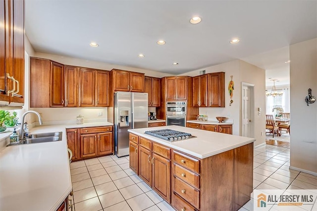 27 Revere Ct, West Windsor, NJ 08550 - kitchen with stainless steel appliances, a sink, light tile patterned flooring, brown cabinetry, and a center island