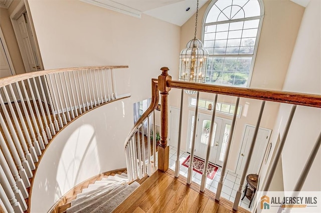 27 Revere Ct, West Windsor, NJ 08550 - staircase featuring high vaulted ceiling, a chandelier, and wood finished floors