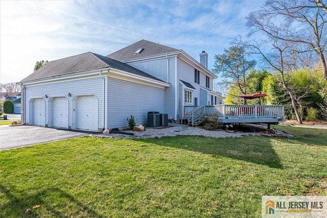 27 Revere Ct, West Windsor, NJ 08550 - view of side of home with a chimney, a yard, a garage, asphalt driveway, and a deck