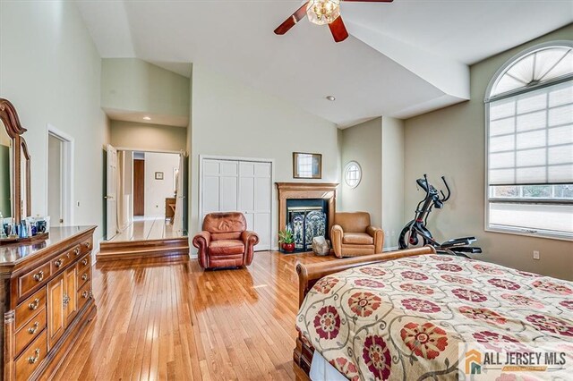 27 Revere Ct, West Windsor, NJ 08550 - bedroom featuring light wood finished floors, a fireplace, high vaulted ceiling, and a ceiling fan