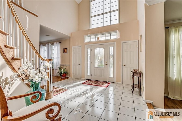 27 Revere Ct, West Windsor, NJ 08550 - tiled foyer entrance with a towering ceiling, stairs, crown molding, and baseboards