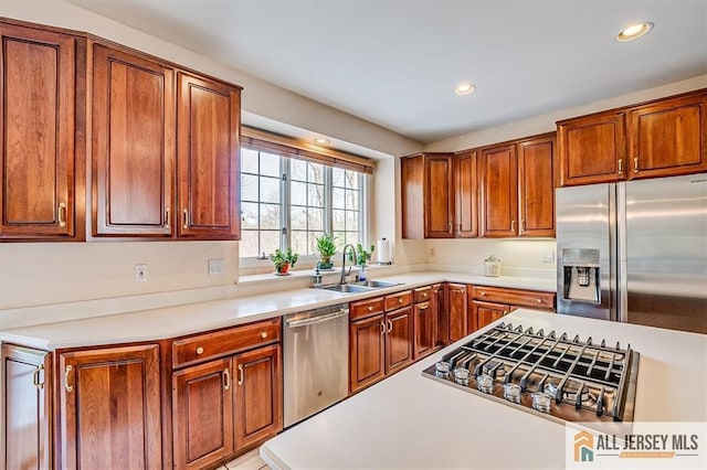 27 Revere Ct, West Windsor, NJ 08550 - kitchen featuring stainless steel appliances, a sink, light countertops, recessed lighting, and brown cabinets