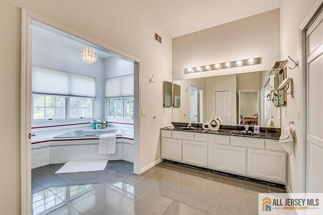 27 Revere Ct, West Windsor, NJ 08550 - bathroom featuring healthy amount of natural light, double vanity, a bath, and baseboards