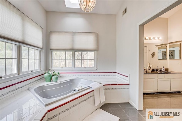 27 Revere Ct, West Windsor, NJ 08550 - kitchen featuring dark tile patterned flooring, white cabinetry, and a sink