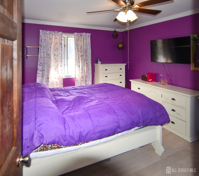bedroom with wood finished floors, a ceiling fan, and ornamental molding