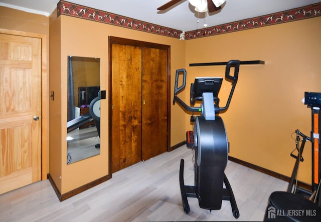 workout room featuring wood finished floors, a ceiling fan, and baseboards