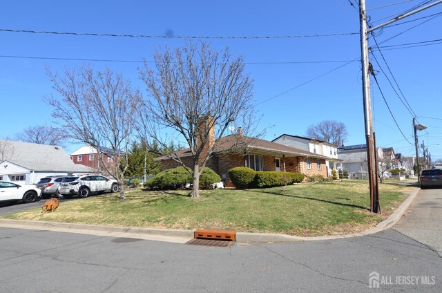 single story home featuring a chimney, brick siding, and a front lawn