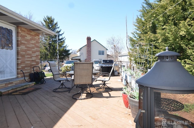 wooden terrace featuring outdoor dining area and area for grilling