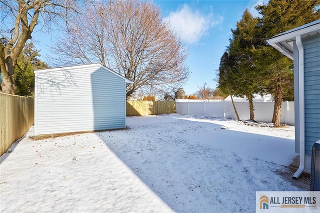 snowy yard featuring a shed