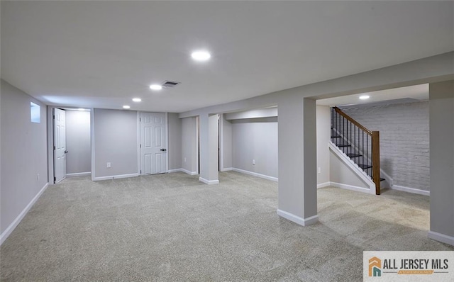 basement featuring light carpet and brick wall