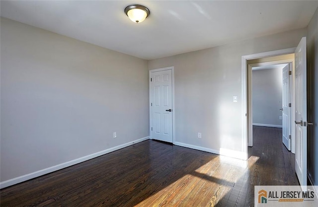 unfurnished room with dark hardwood / wood-style floors