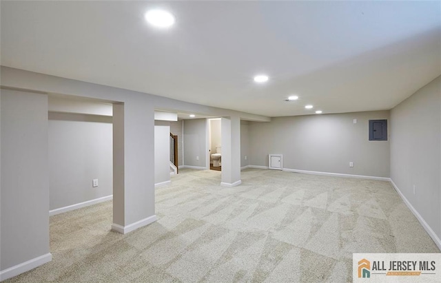 basement featuring light colored carpet and electric panel