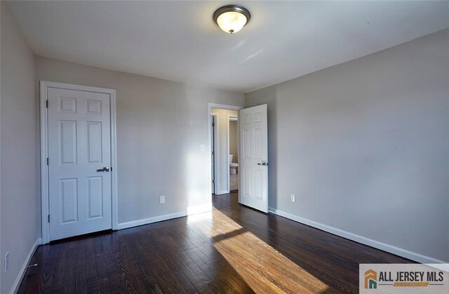 unfurnished bedroom featuring dark hardwood / wood-style floors