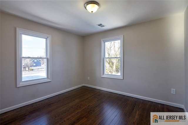 empty room with dark hardwood / wood-style flooring