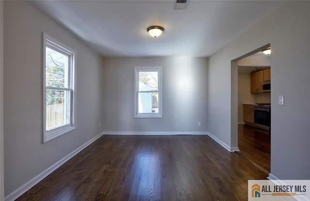 unfurnished room with dark wood-type flooring