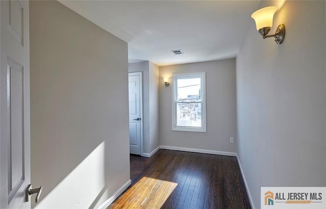 unfurnished room with dark wood-type flooring