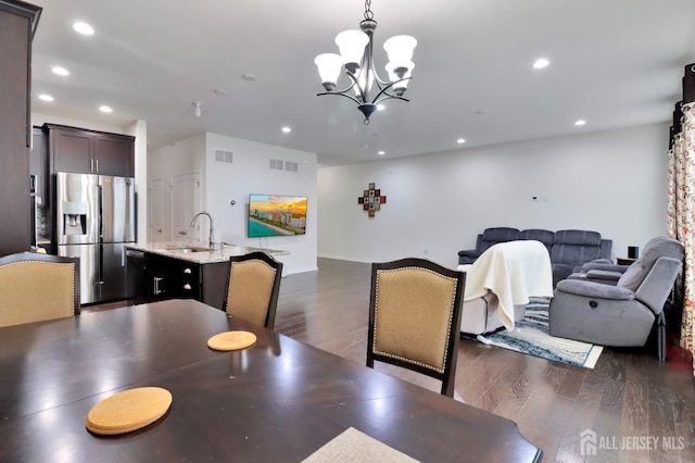 dining room featuring dark wood-style floors, recessed lighting, and a chandelier