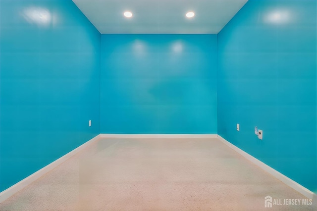carpeted empty room featuring baseboards and recessed lighting