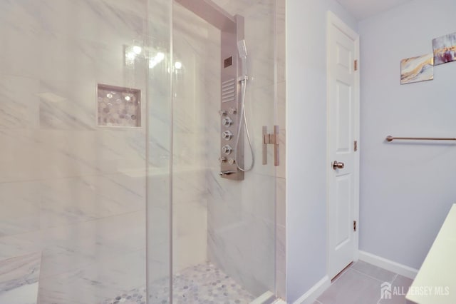 bathroom featuring a marble finish shower and tile patterned flooring