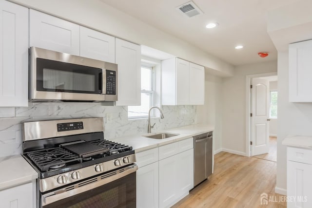 17-1/2 Thomas St, South River, NJ 08882 - kitchen with appliances with stainless steel finishes, light wood-style flooring, recessed lighting, and white cabinets