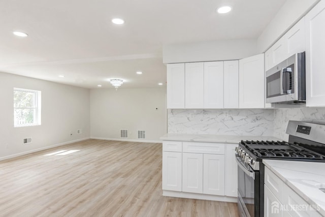 17-1/2 Thomas St, South River, NJ 08882 - kitchen with appliances with stainless steel finishes, tasteful backsplash, recessed lighting, white cabinets, and light wood-style flooring