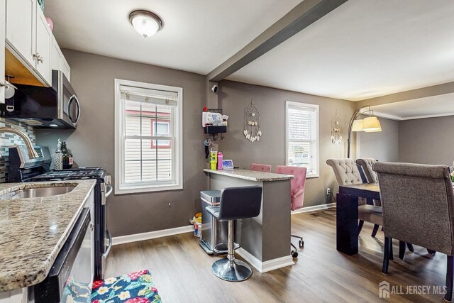 20 S So 8th Ave, Manville, NJ 08835 - kitchen featuring plenty of natural light, wood finished floors, stainless steel appliances, and baseboards