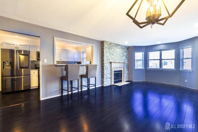 20 S So 8th Ave, Manville, NJ 08835 - unfurnished living room featuring dark wood-type flooring, a stone fireplace, and baseboards
