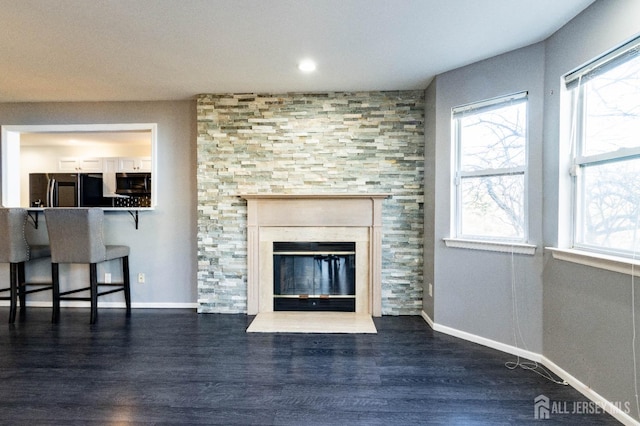 20 S So 8th Ave, Manville, NJ 08835 - unfurnished living room with dark wood-style flooring, baseboards, and a fireplace