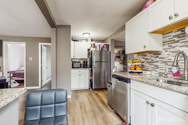 20 S So 8th Ave, Manville, NJ 08835 - kitchen with stainless steel appliances, a sink, backsplash, and white cabinetry