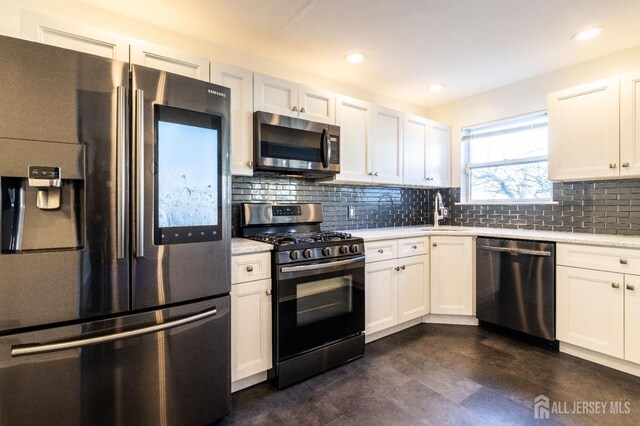 20 S So 8th Ave, Manville, NJ 08835 - kitchen with appliances with stainless steel finishes, a sink, decorative backsplash, white cabinets, and recessed lighting