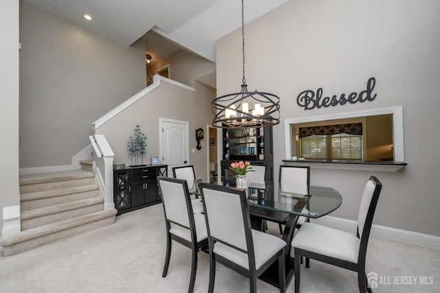 dining area featuring a notable chandelier, light carpet, high vaulted ceiling, stairs, and baseboards