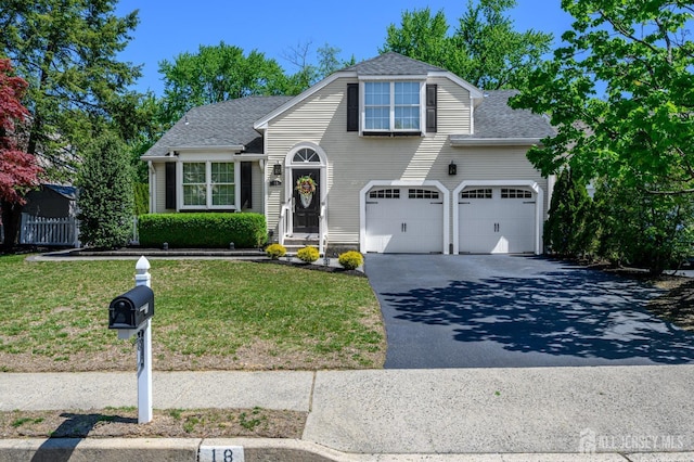 view of front facade featuring a garage, driveway, roof with shingles, and a front lawn