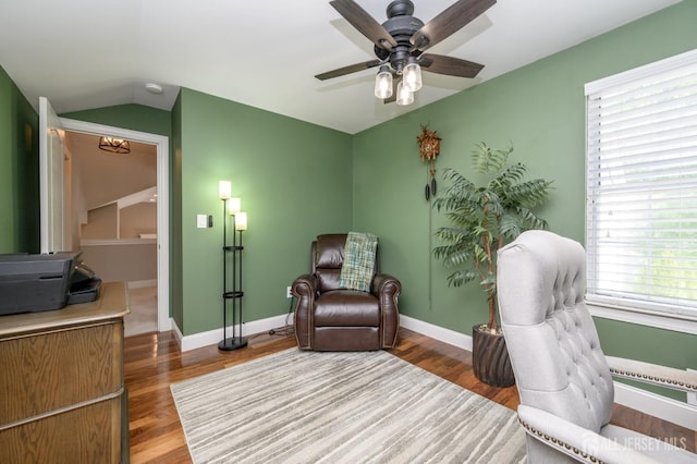 sitting room featuring baseboards, a ceiling fan, wood finished floors, and lofted ceiling