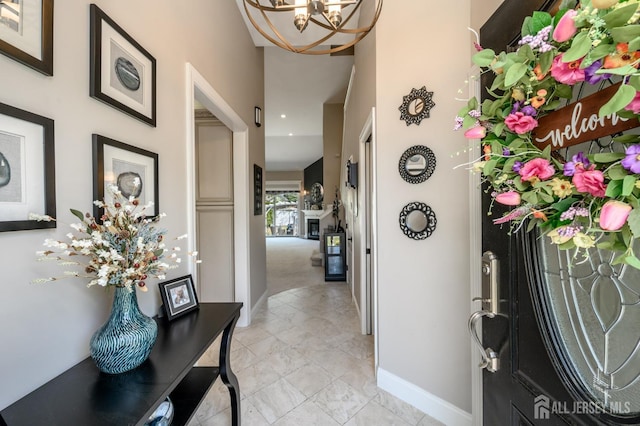 entrance foyer with baseboards, marble finish floor, recessed lighting, and a notable chandelier