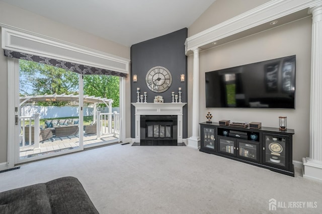 living room featuring ornate columns, baseboards, a fireplace with flush hearth, and carpet