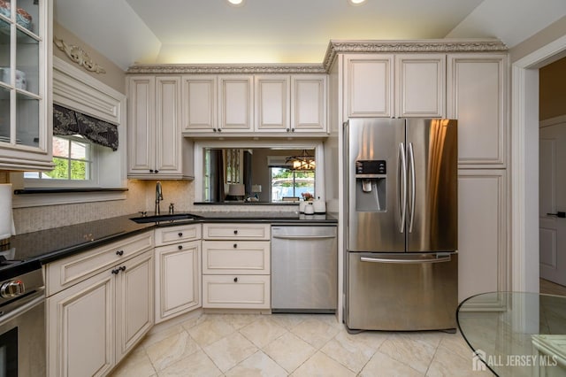 kitchen featuring cream cabinets, stainless steel appliances, a wealth of natural light, and a sink