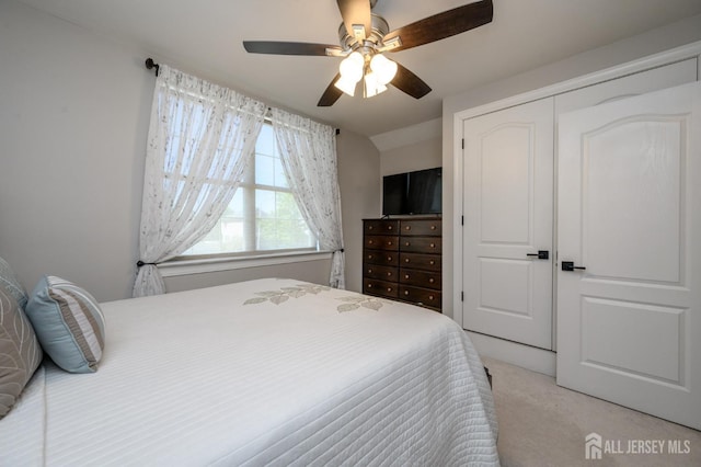 bedroom featuring ceiling fan, a closet, and light colored carpet