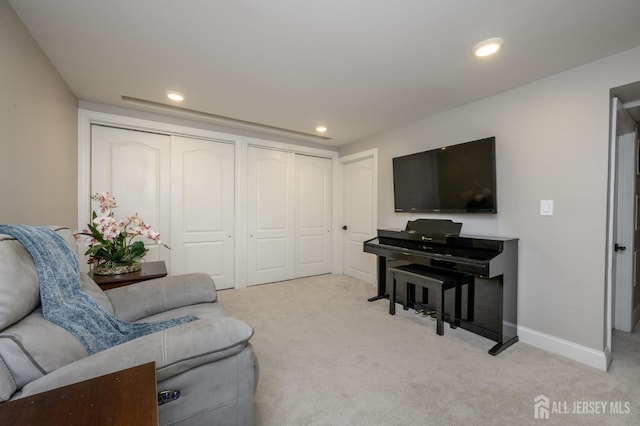 living area featuring baseboards, recessed lighting, and light colored carpet