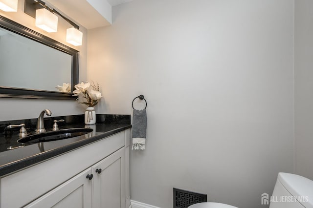 half bathroom with visible vents, toilet, and vanity